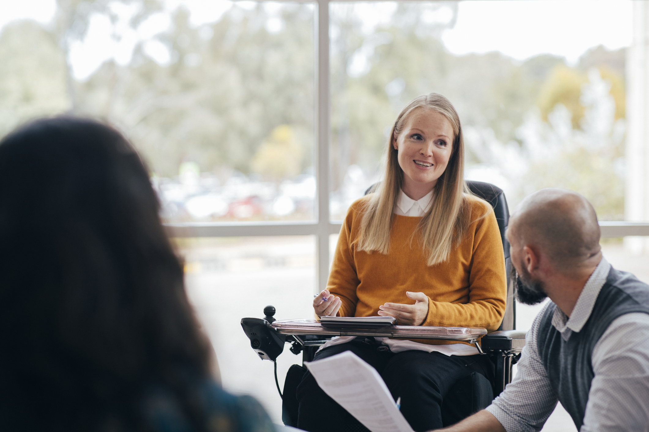 Woman in a wheelchair speaking to a group