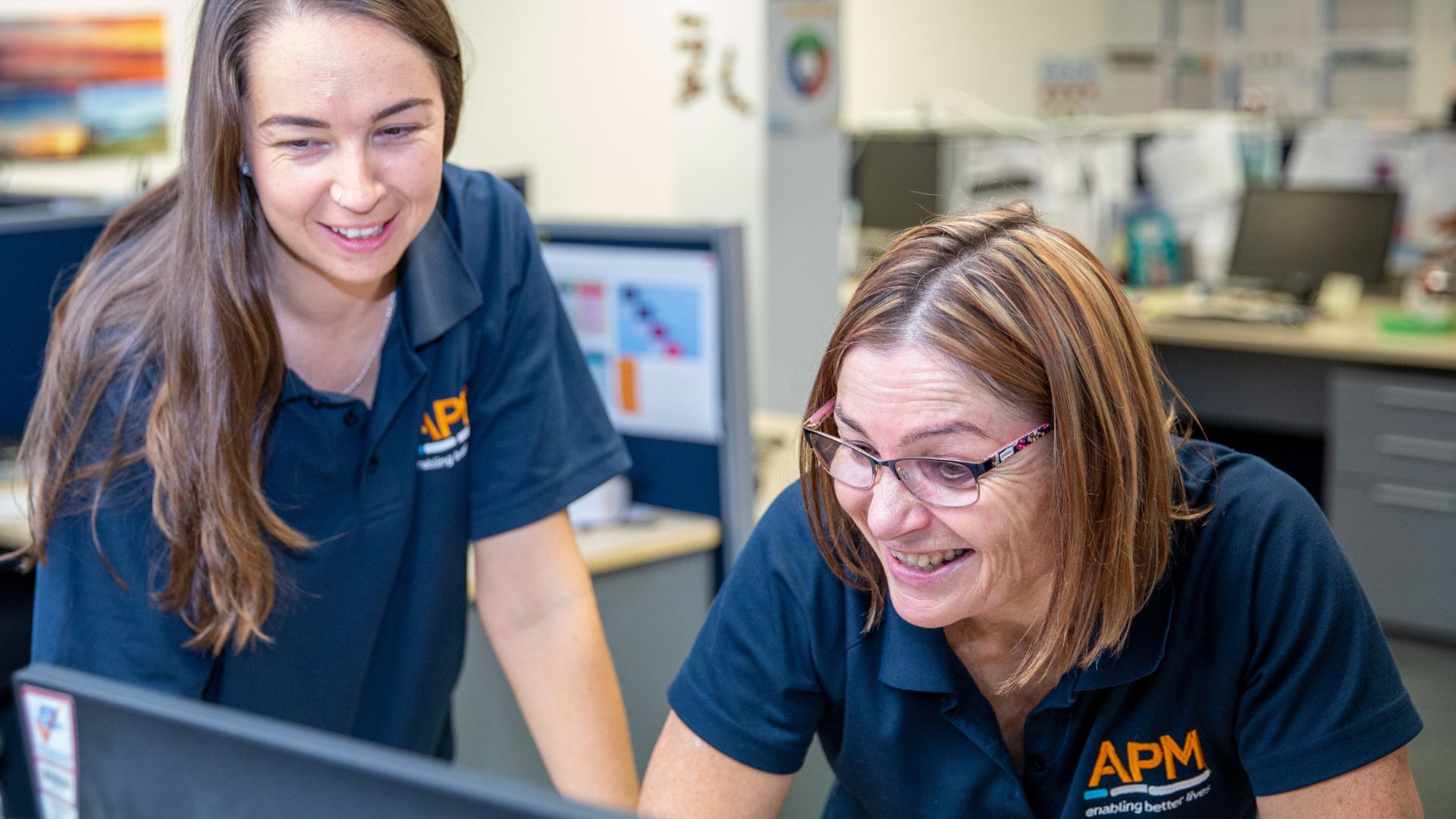 APM Physios in front of a computer