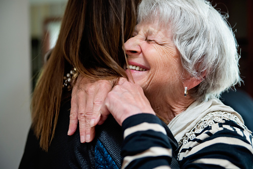 Older woman joyfully embracing younger family member