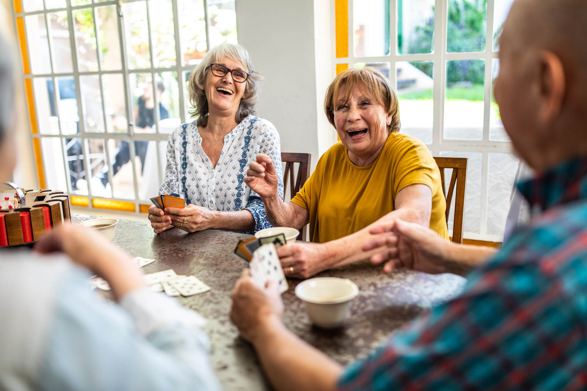 Group of senior people smiling and laughing around a table