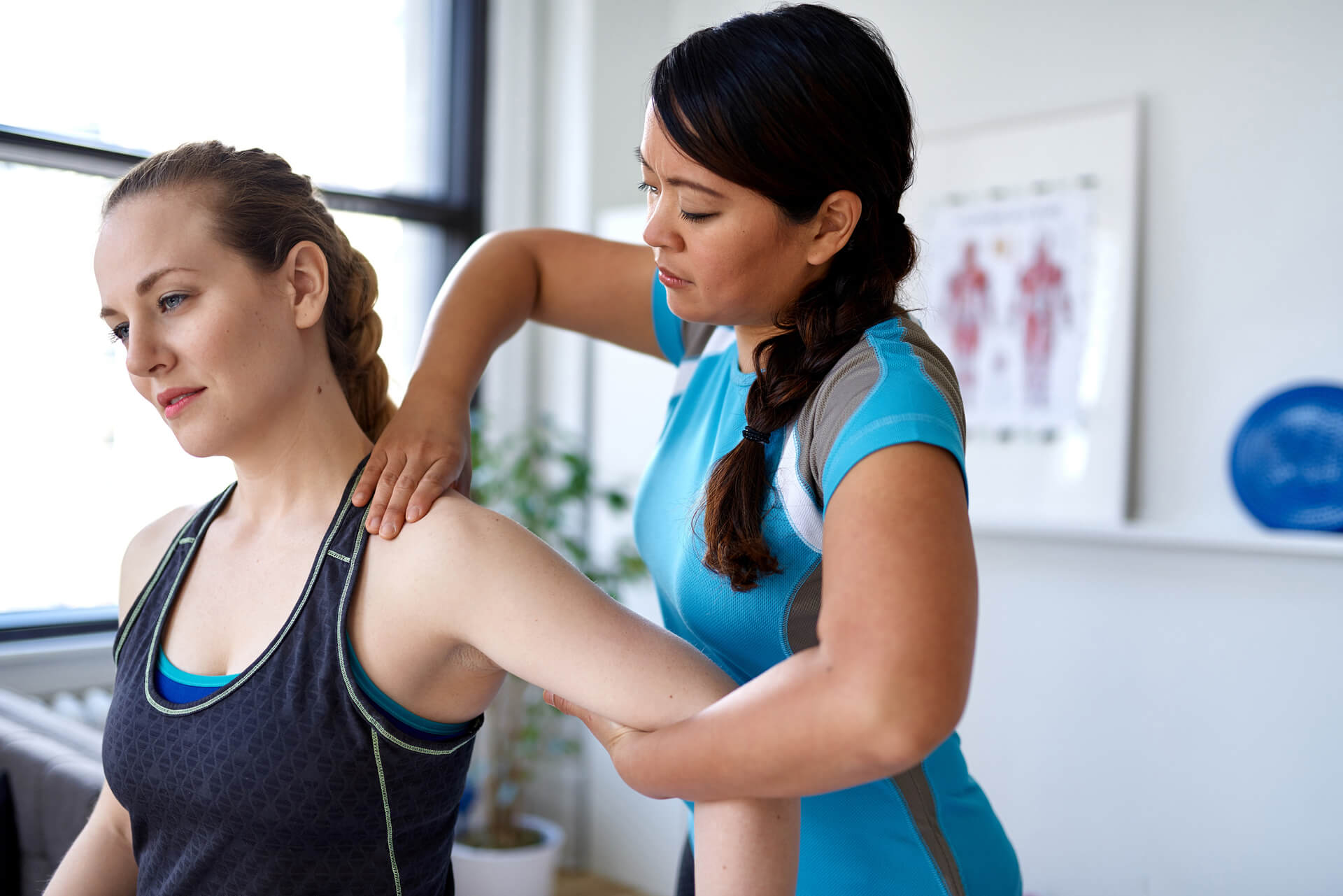 Physio massages patient's arm in a clinic