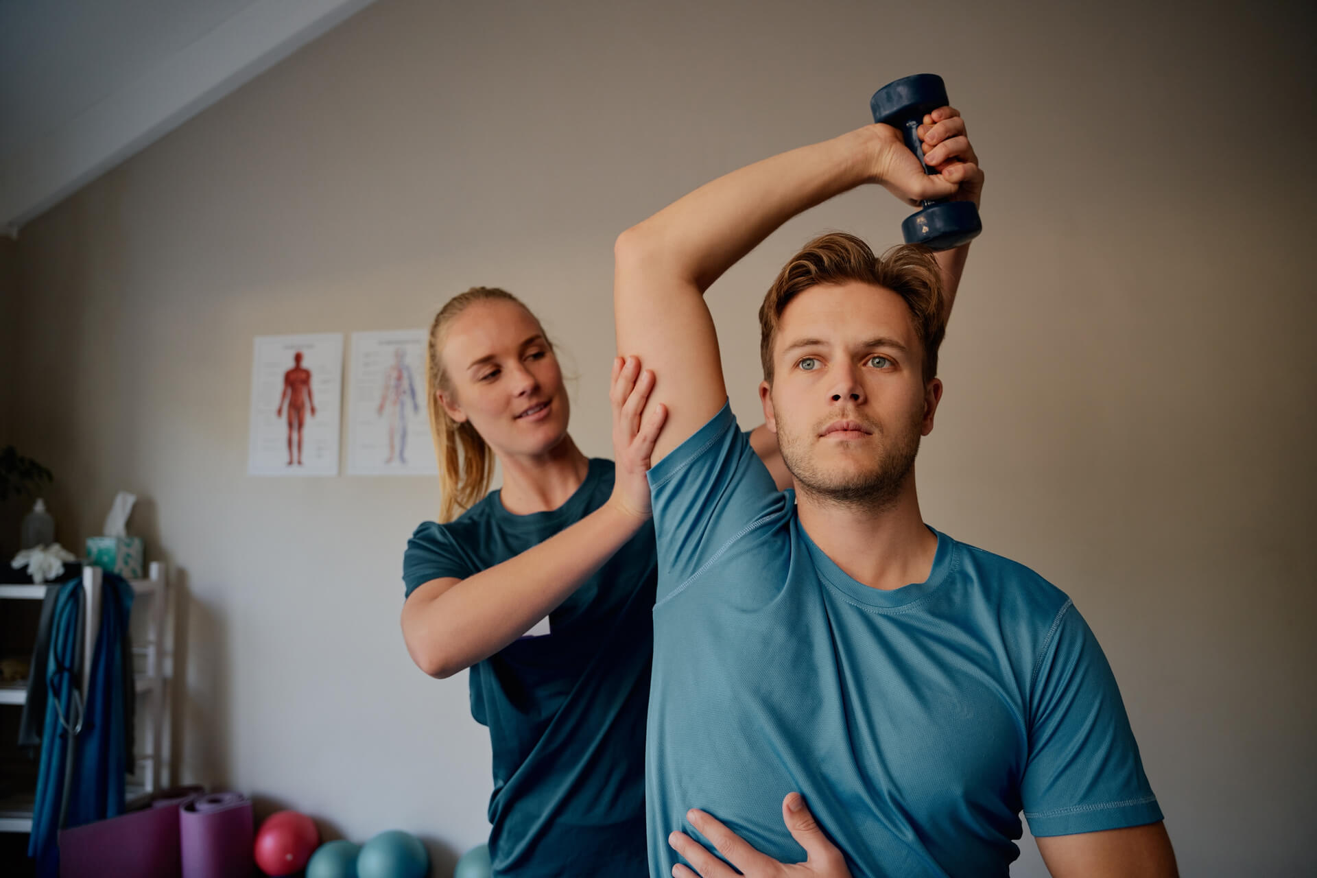 Physio helping man with arm exercise